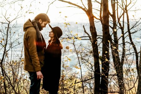 attractive happy luxury couple hugging and holding hands with tender in autumn colorful parkの写真素材