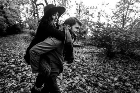 attractive happy luxury couple having fun and laughing in autumn colorful parkの写真素材