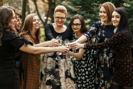 group of luxury elegant women celebrating and clicking with champagne, cheerful moment happinessの写真素材