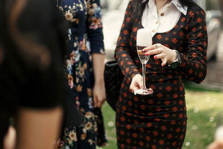 luxury elegant woman holding glass of champagne and toasting at celebration in restaurant terraceの写真素材