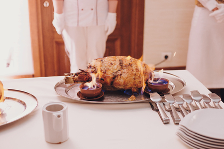 Delicious meat in fire at wedding reception in restaurant. Chef cooking tasty meal with fire show, luxury catering. Smoked meat in flames. Thanksgiving feastの写真素材
