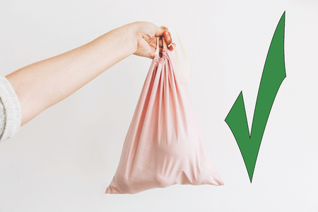 Choose eco friendly natural bags, green approve. Woman holding in hand groceries in reusable eco bag. Zero Waste shopping concept. Reuse, reduce, refuse. Ban single use plasticの写真素材