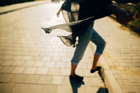 Stylish hipster girl walking in sunny light in street, atmospheric moment. Fashionable cool woman in...