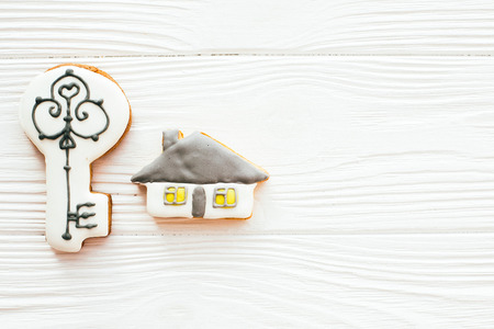 Key, house, welcome sign cookies on white wood, flat lay with space for text. Dream home concept. Home Sweet Home. Moving in new house, Welcome home set.の写真素材