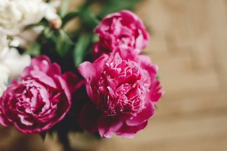 Beautiful pink and white peonies bouquet in glass jar on rustic wooden floor , flat lay. Floral decor and arrangement. Gathering flowers. Rural still life, countryside flowersの写真素材