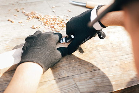Wooden workshop. Hands carving spoon from wood, working with chisel close up. Process of making...