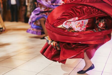 Beautiful gypsy girls dancing in traditional colorful clothing. Roma gypsy festival. Woman performing romany dance and singing folk songs in national dresses at wedding receptionの写真素材