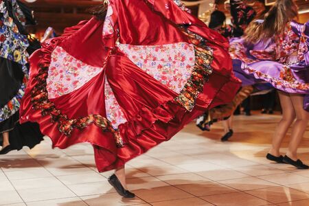 Beautiful gypsy girls dancing in traditional colorful clothing. Roma gypsy festival. Woman performing romany dance and singing folk songs in national dresses at wedding receptionの写真素材