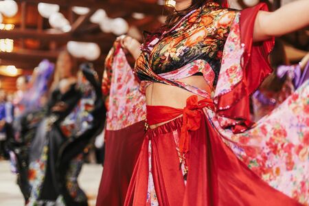 Gypsy dance festival, Woman performing romany dance and folk songs in national clothing. Beautiful roma gypsy girls dancing in traditional floral dress at wedding reception in restaurantの写真素材