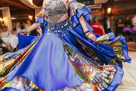 Beautiful gypsy girls dancing in traditional colorful clothing. Roma gypsy festival. Woman performing romany dance and singing folk songs in national dresses at wedding receptionの写真素材