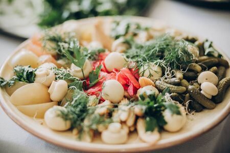 Mushrooms, baby corn, cucumber, ginger,greenery appetizers on plate at wedding or christmas feast....