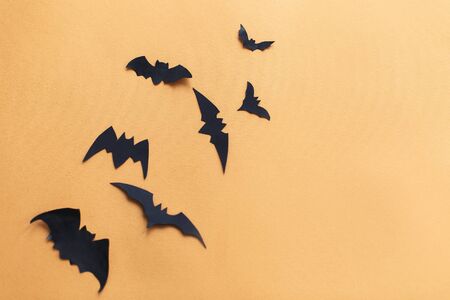 Halloween flat lay. Black paper bats flying on yellow paperの写真素材