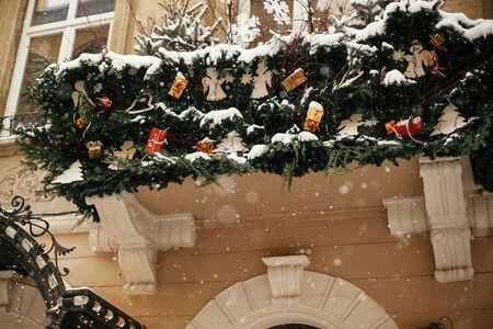 Christmas street decor. Stylish christmas fir branches with golden lights and festive ornaments on...