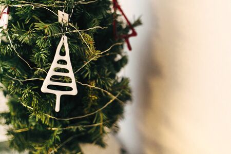 Stylish glass ornaments hanging on christmas tree. Modern glass toy, creative abstract white tree on christmas tree. Festive decor. Scandinavian minimal decorationの写真素材