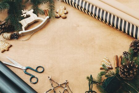 Wrapping christmas gift in stylish striped paper and pine branchesの写真素材