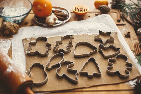 Making christmas gingerbread cookies. Raw dough with metal cutters for cookies and wooden rolling...