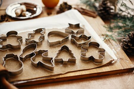 Gingerbread dough with metal cutters in different shapes for christmas cookies and wooden rolling...