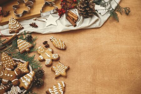 Christmas gingerbread cookies on vintage plate and anise, cinnamon, pine cones and cedar branches on...
