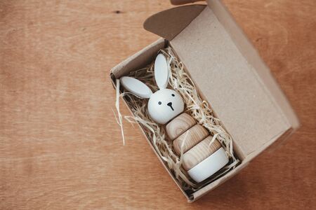 Stylish wooden toy for child in craft box on wooden table. Modern  wooden pyramid with bunny. Eco friendly plastic free toys for toddler.  Educational  toyの写真素材