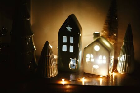 Merry Christmas and New Year. Christmas little houses with lights and  trees in night. Miniature houses among pine tree in christmas evening. Stylish festive decorations,winter wonderlandの写真素材