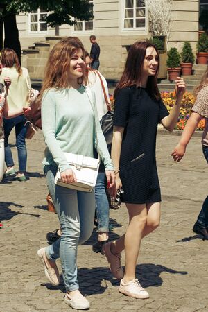 many young happy women walking talking  on background of old european city street, stylish hipster...