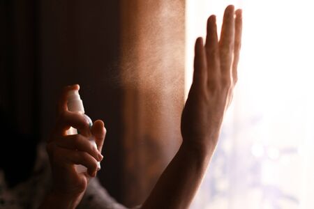 Disinfecting hands. Person using antiseptic spray on hands to  prevent coronavirus or flu disease. Personal hygiene. How to clean hands right. Wash your handsの写真素材