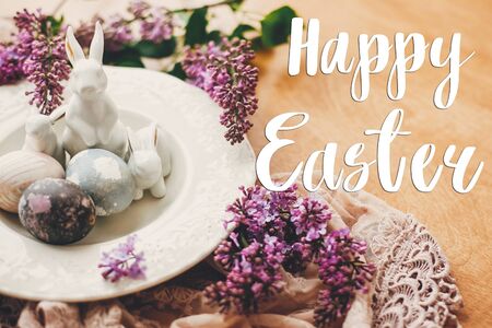 Happy Easter text. Easter greetings card. Rustic composition of natural dyed easter eggs, lilac...
