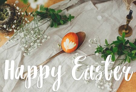 Happy Easter text. Easter greetings lettering. Modern Easter egg with floral ornament on rustic...