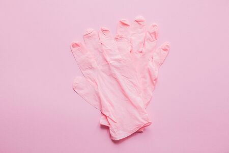 Pink gloves on pink background flat lay. Coronavirus pandemic. Stay safe. Prevention of virus epidemic. Safe shopping and walking outside in quarantine. Stay home safe livesの写真素材