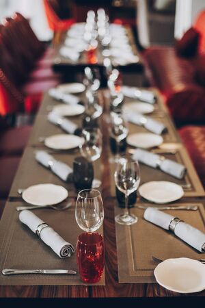 Luxury red table setting at reception in restaurant for wine party or wedding. Stylish glasses for...