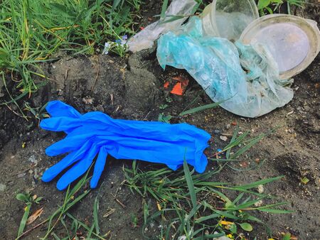 Disposable medical gloves on ground with single use plastic trash. How to dispose used medical gloves right after coronavirus pandemic. Do not throw them awayの写真素材