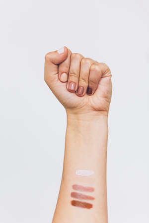 Female fist protesting on white background. Female hand raised up with different nails colors, skin and race diversity. Women rights concept. Stop racismの写真素材