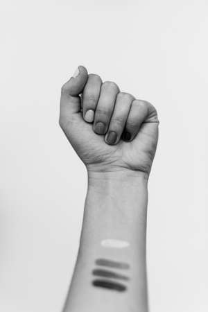 Protest. Female fist protesting, black and white photo. Female hand raised up, strong and power concept. Women rights fight, skin and race diversity. Stop racismの写真素材