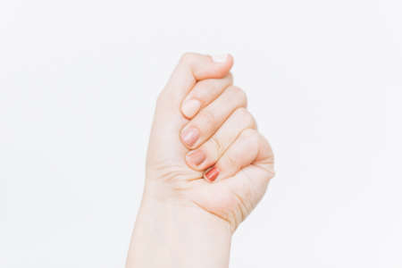 Female nails with different pastel colors on white background. Home modern manicure. Female hand raised up. Woman rightsの写真素材
