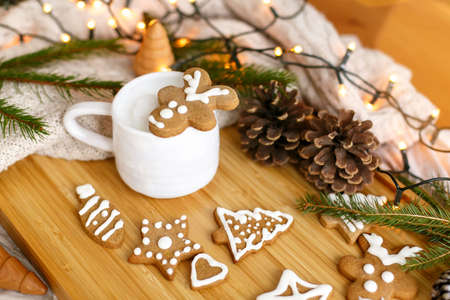 Christmas  gingerbread reindeer cookie on aromatic coffee on background of cozy knitted sweater,...