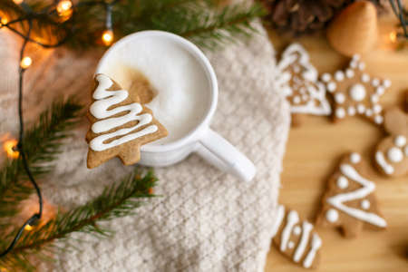 Christmas tree gingerbread cookie on aromatic coffee on background of pine cones, fir branches and...