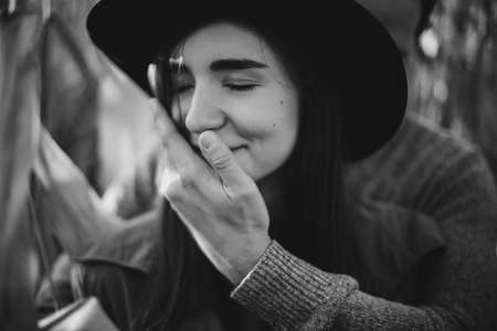 Young man gently hugging his fashionable woman, touch close up. Happy stylish couple embracing in autumn corn field in sunset light. Romantic sensual moment, black and white photoの写真素材