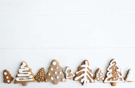 Christmas gingerbread cookies on white wooden background, flat lay with space for text. Tasty...
