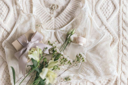 Happy Women's day. Stylish lace lingerie, perfume bottle, modern jewelry and gift box on cozy beige...