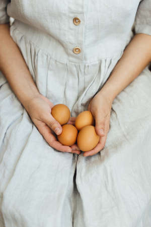Woman in rustic linen dress holding natural easter eggs  in hands. Happy Easter! Natural eco eggs....