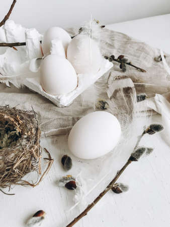 Simple stylish Easter still life. Natural easter eggs, soft feathers, pussy willow branches, bird...