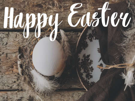 Happy Easter greeting card. Happy Easter text sign handwritten on  easter egg in nest with soft feathers and vintage plate with napkin on rustic aged wood. Beautiful postcard, seasons greetingsの写真素材