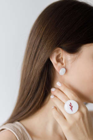 Beautiful sensual woman with modern round ring and earring, close up view. Fashionable female with...