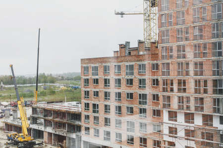 Building construction site and crane. Industrial landscape with machinery, building bricks and...