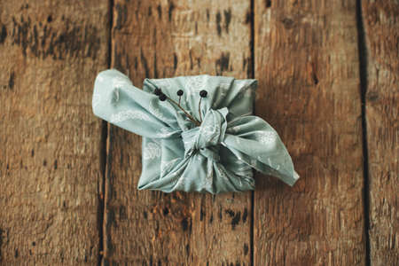 Zero waste gift flat lay. Furoshiki eco friendly simple present. Stylish christmas gift wrapped in...