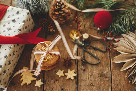 Christmas cookies, gift, festive decorations on rustic wooden table. Atmospheric stylish christmas composition. Xmas present, healthy oatmeal cookies, ornaments. Holiday moody image. Merry Christmasの写真素材