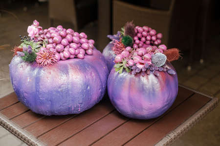 Purple pumpkins in city street, festive holiday decor of storefronts and buildings. Halloween modern decoration outdoor. Happy halloween. Autumn market in town, painted pumpkinの写真素材