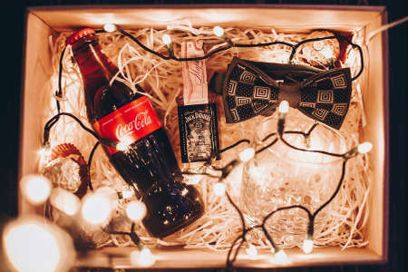 Lviv, Ukraine - December 1, 2017: Stylish bow tie, coca cola, jack daniels whiskey, glass cup and...