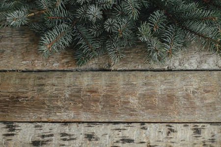 Christmas tree fir branches border on rustic old wooden background. View above with space for text. Season's greeting card. Merry Christmas and Happy Holidays!の写真素材
