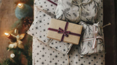 Merry Christmas ! Stylish christmas gifts wrapped in craft paper, vintage candles, fir branches and...